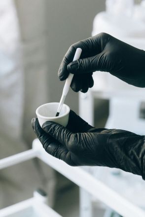 Close-up of hands applying permanent makeup with precision brush.