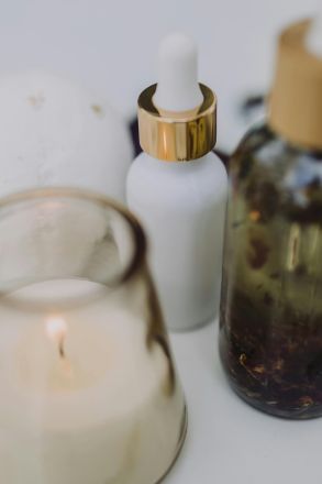 A calming spa setup featuring an aromatherapy candle, essential oils, and dried lavender for relaxation.